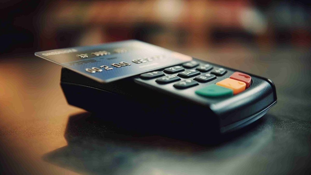 A bank card placed on top of a card reader for payment processing