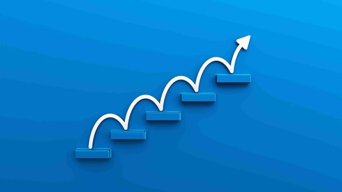 A blue metallic block arrangement forms a stair-like structure, topped with a white upward-pointing arrow