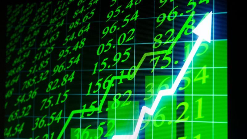 A close-up of a bright green stock market graph showing an upward trend.