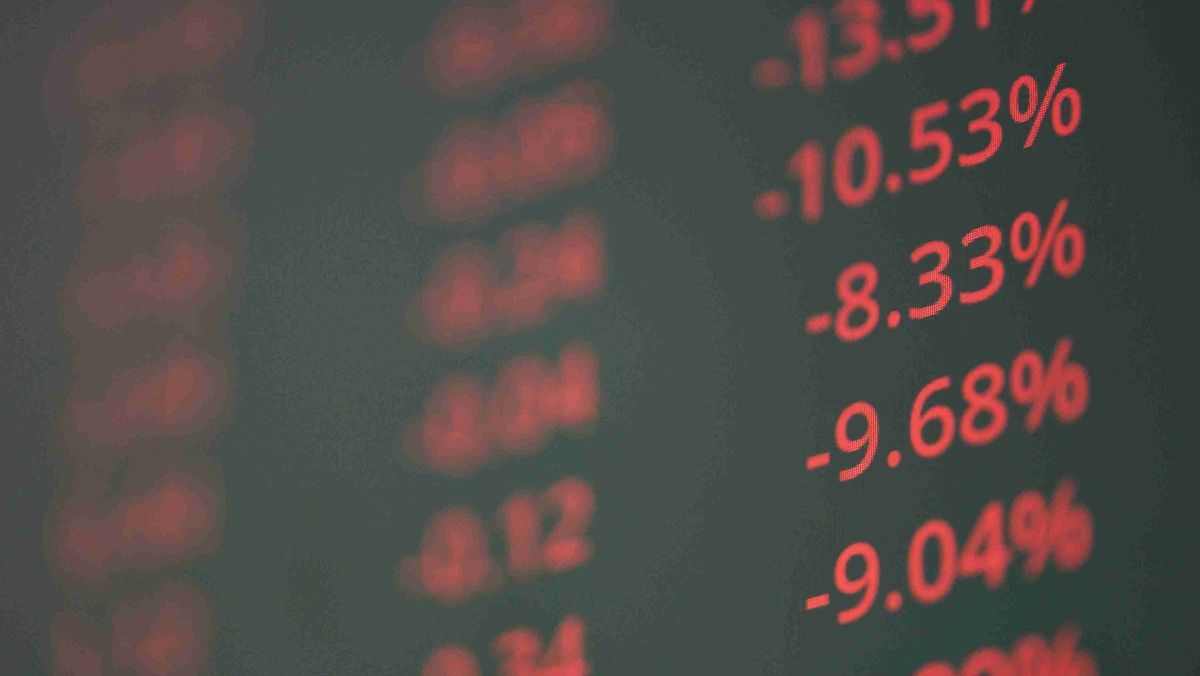 A digital display showing red numerical figures indicating a decline in the stock market