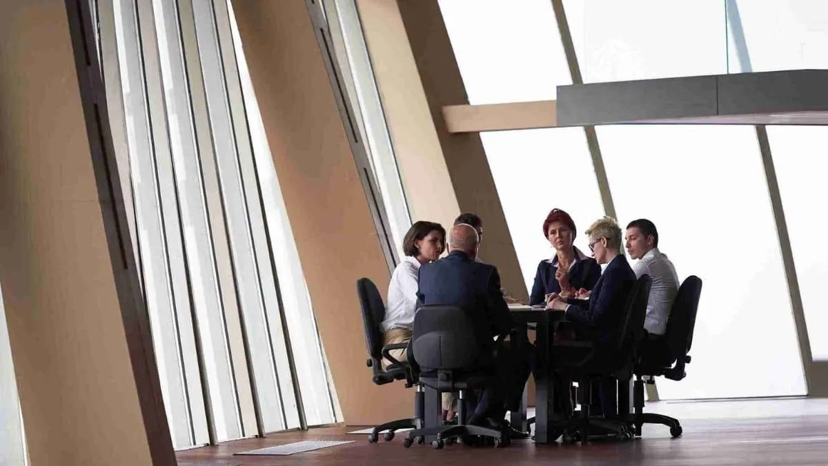 A gathering of business professionals conducting a meeting in an open space