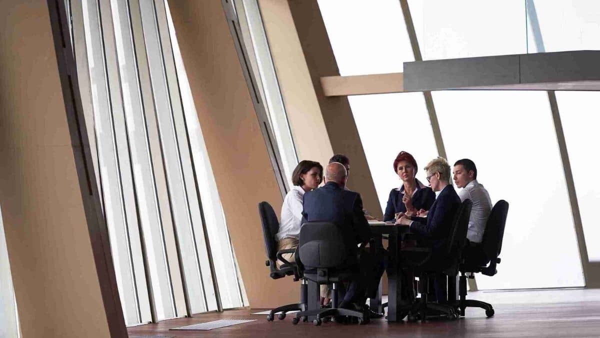 A gathering of business professionals conducting a meeting in an open space