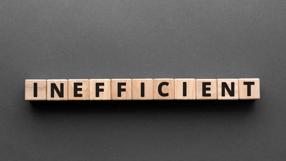 Wooden blocks spell INEFFICIENT on a grey background