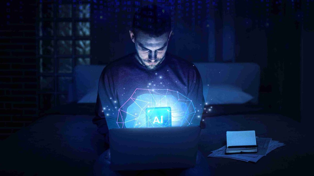 A man using a laptop, the display features a bright and captivating AI graphic