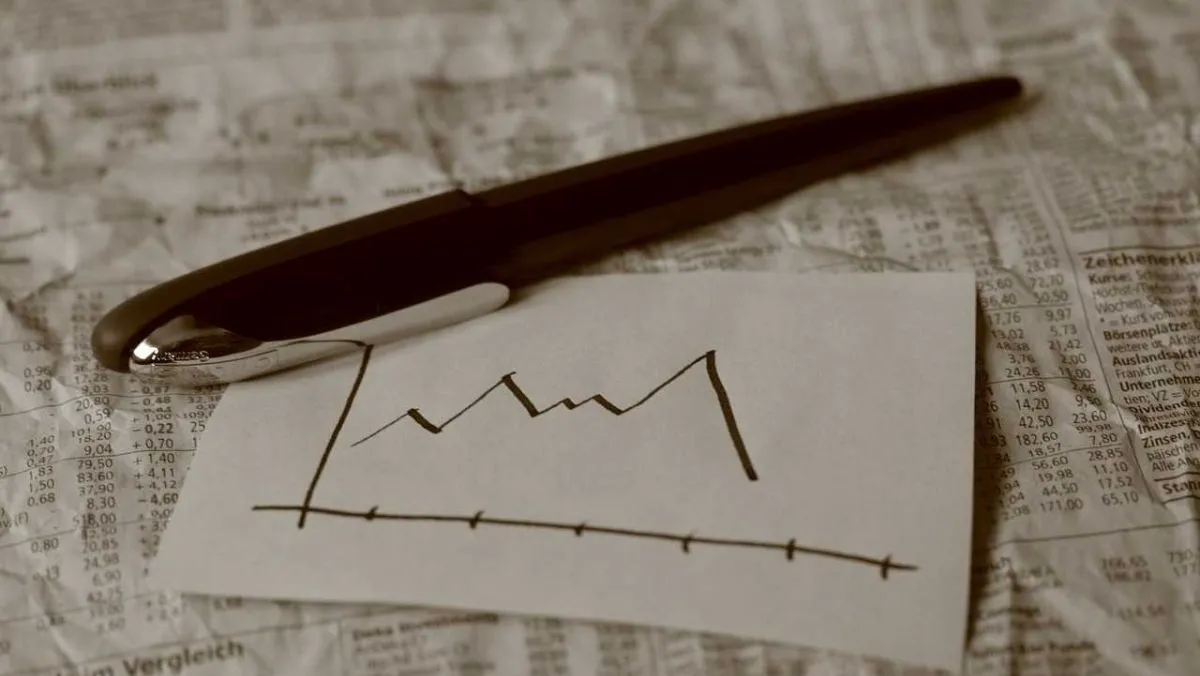 A pen and paper featuring a sketch of a graph placed atop a crumpled sheet