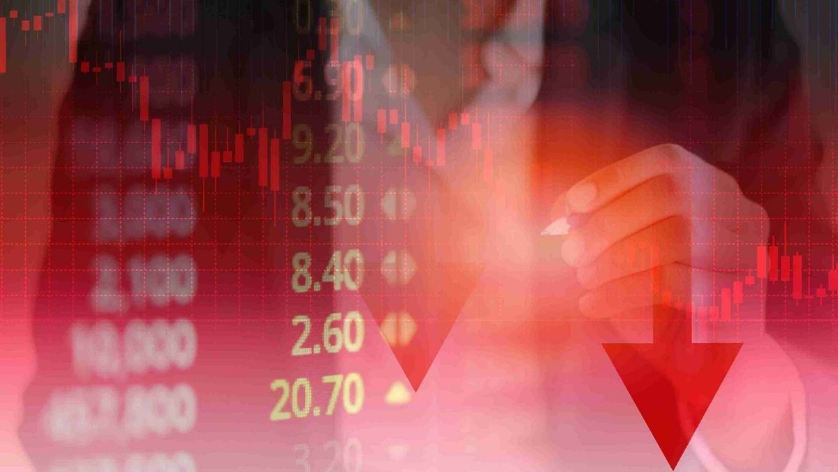 A person gestures in the backdrop emphasizing a red colored trading chart and data