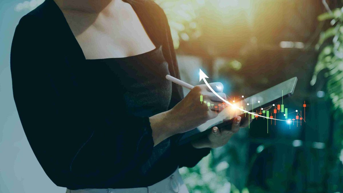 A person holding a tablet and pen featuring a holographic display depicting trade patterns
