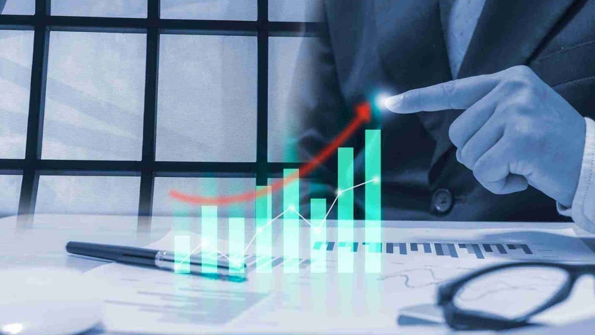 A person pointing the upward trajectory of an arrow above the bar graph