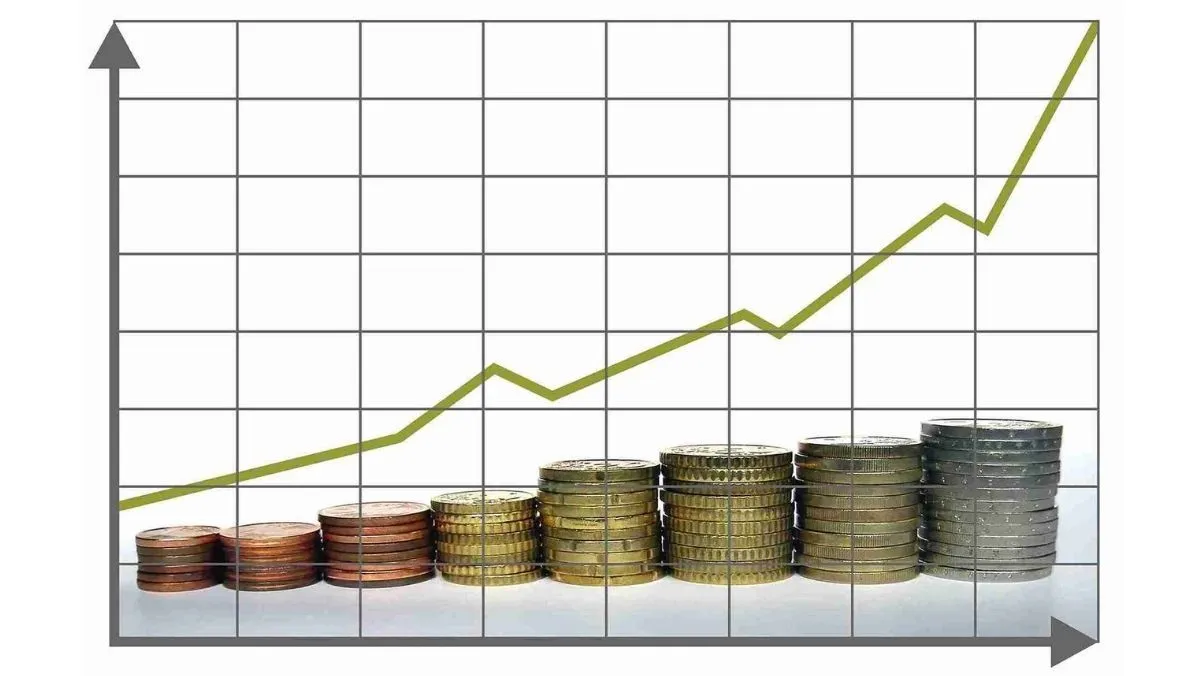 A stack of coins neatly arranged upward, set against the backdrop of a graph