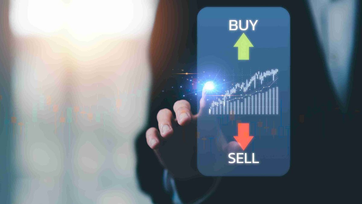 A touchscreen display with a focused finger indicating the buy and sell buttons