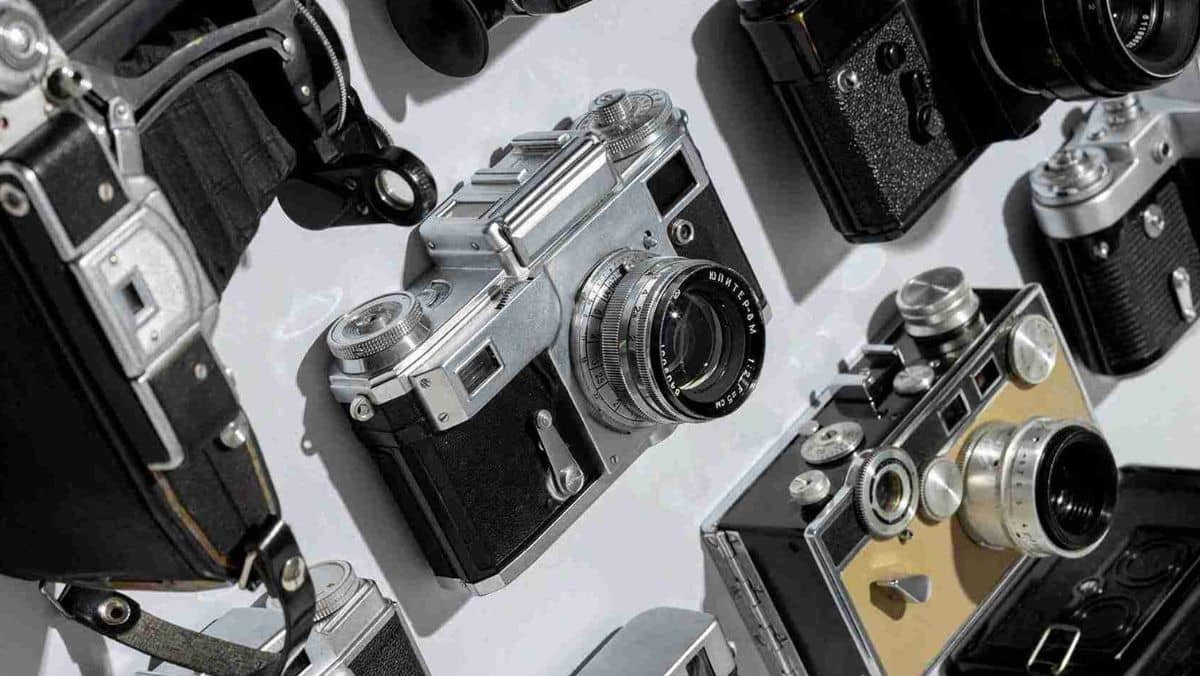 An organized display of various cameras neatly arranged in a row