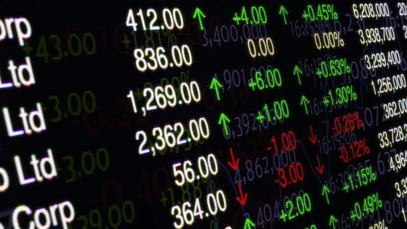 Close up of a stock market data screen showing numerical values with green and red indicators