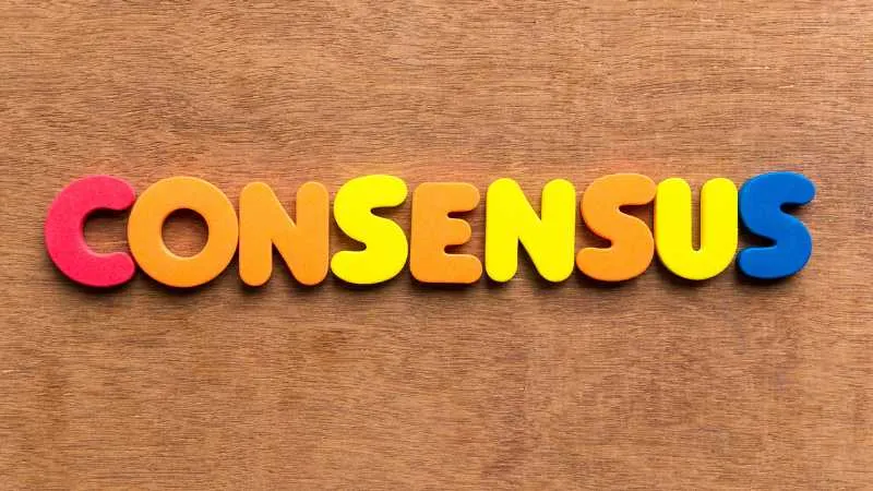 Colorful letters spelling CONSENSUS on a wooden background.jpg