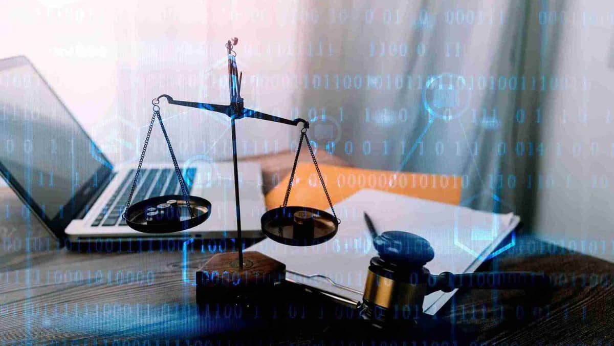 Documents with brass scale on the desk a gavel and a laptop
