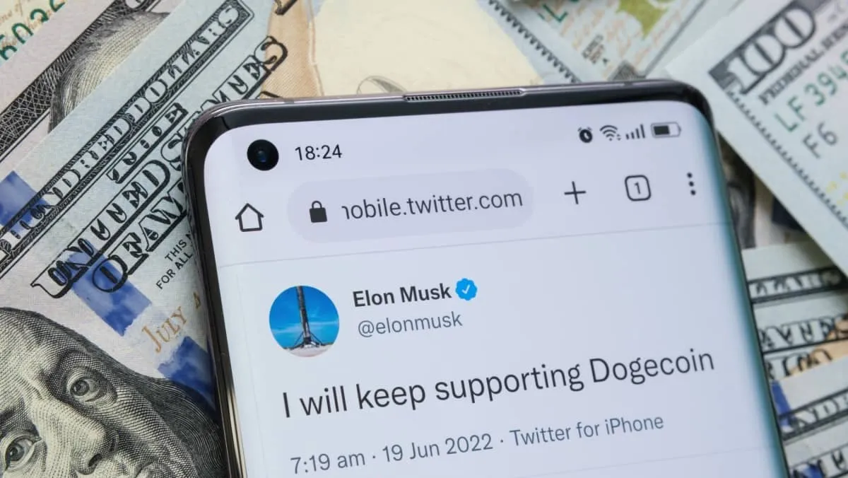 Elon Musk's tweet about Dogecoin support seen on smartphone placed on dollar bills. Concept. Stafford, United Kingdom.