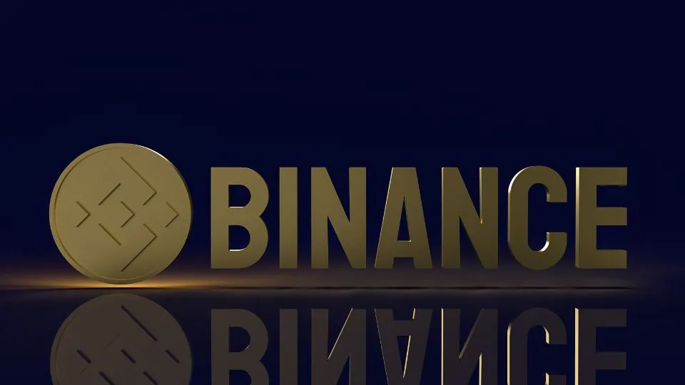 Gold Binance coin with the Binance logo illuminated on a dark background, symbolizing the Binance cryptocurrency exchange