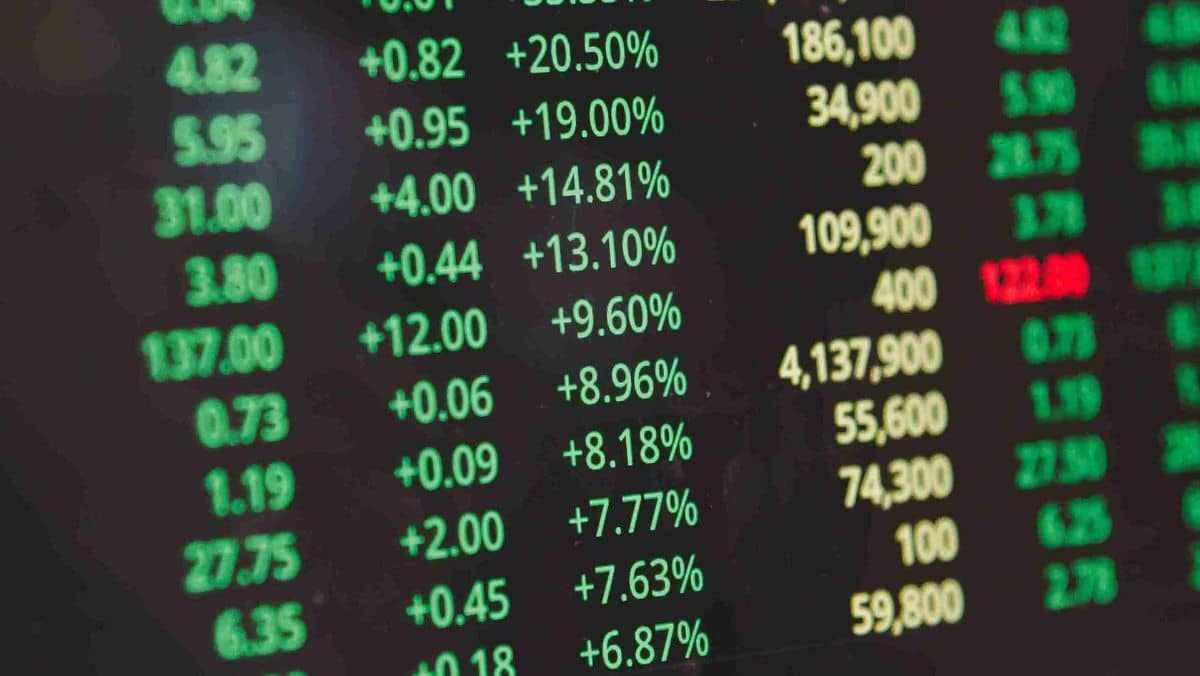 Green, yellow, and red colored stock market data displayed on a digital screen