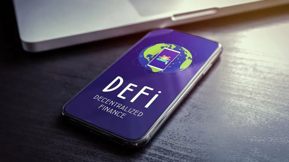 Smartphone on a desk displaying DeFi application logo, representing decentralized finance on mobile