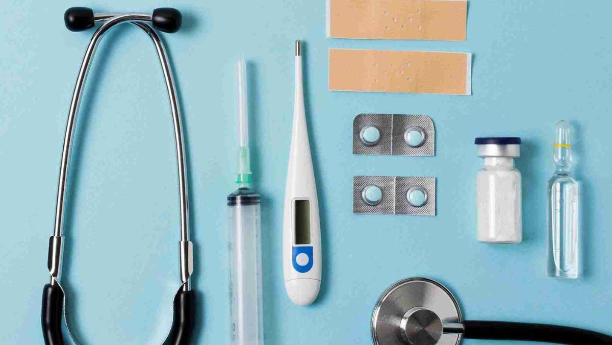 Stethoscope bandages syringe and various medical tools neatly arranged on a flat surface