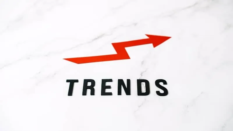 The word TRENDS with an upward red arrow on a marble background