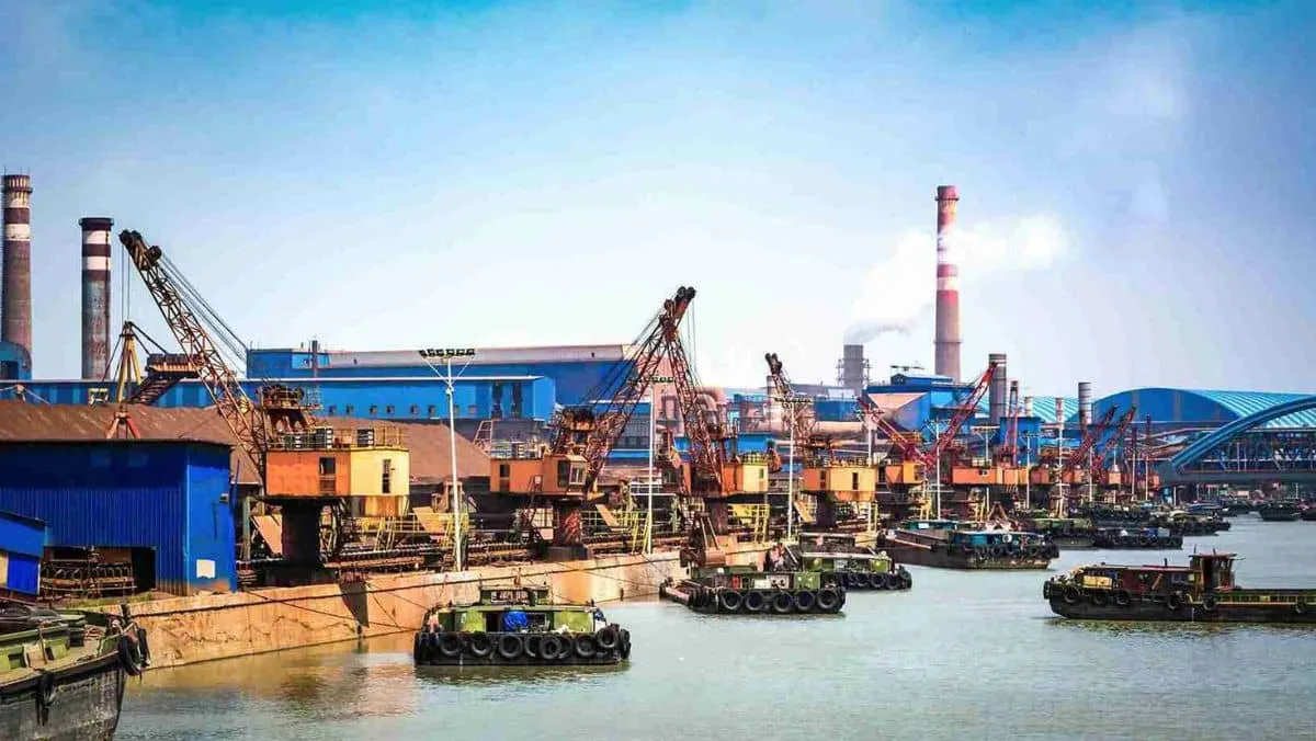 Vessels transporting petroleum gas containers with a backdrop of an oil refinery