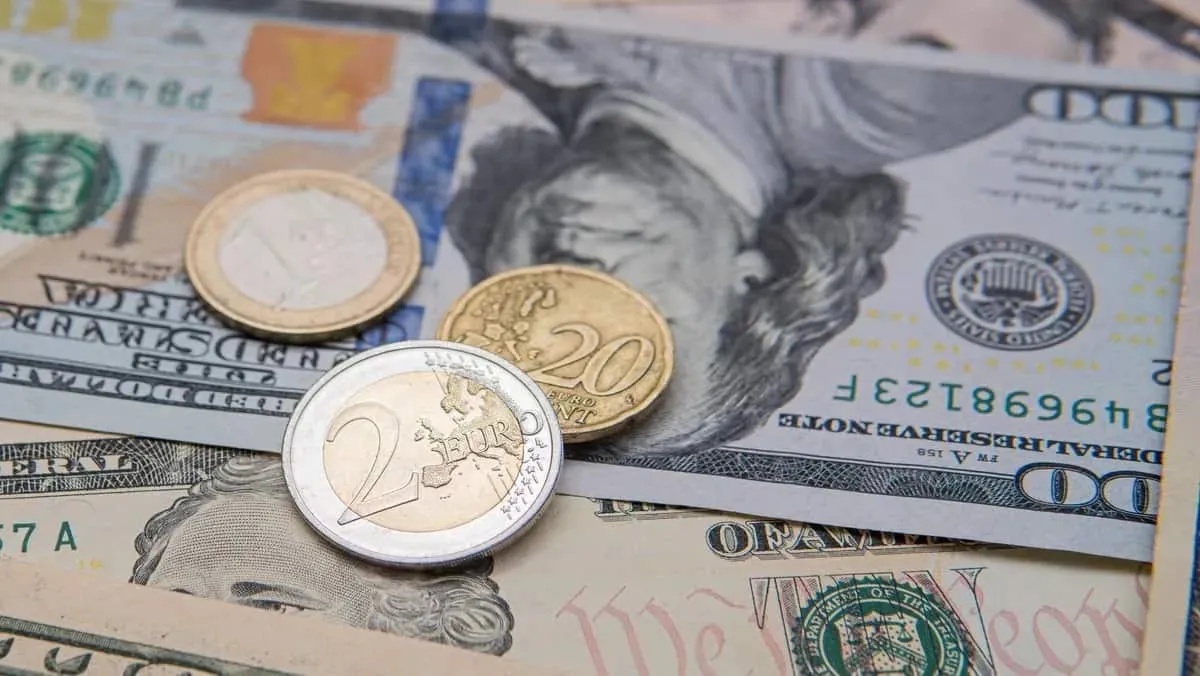 euro_coins_on_background_american_dollars_width_1200_format_JPEG.jpg