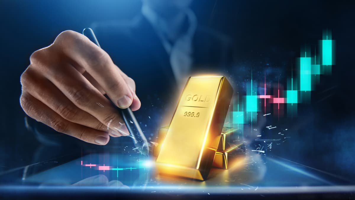 hand-holding-a-pen-pointing-at-the-candle-chart-behind-gold-bars-width-1200-format-jpeg.jpg